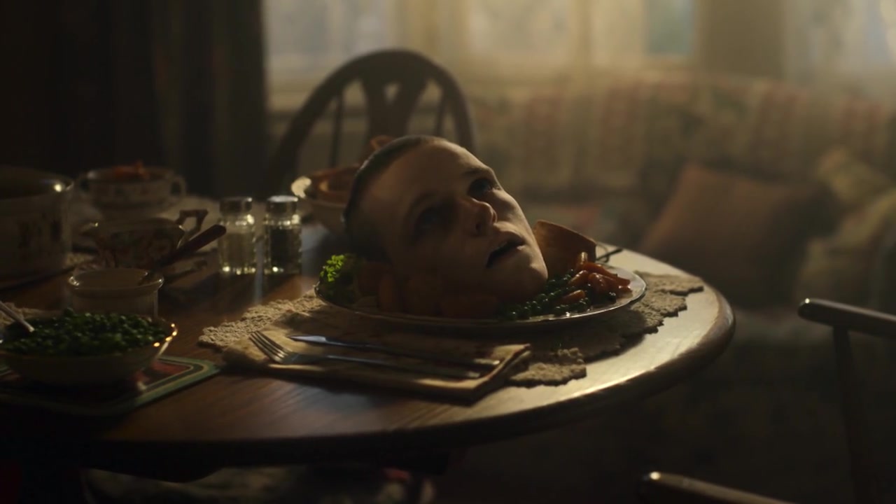 A severed head served on a plate at a family dinner table